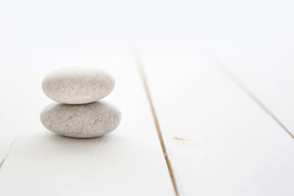 zen stones on white wooden background.