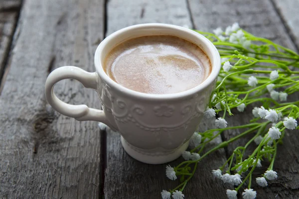 Masaya siyah kahve ve beyaz çiçek fincan