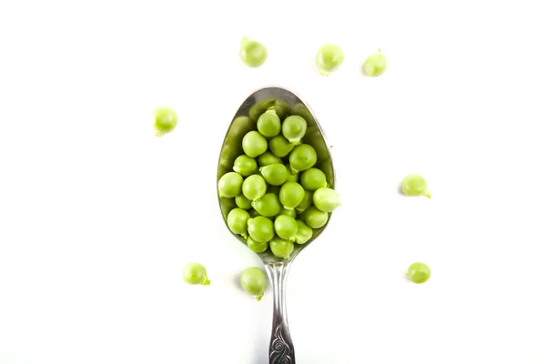 Delicious, green, canned peas in a silver spoon on a white — Stock Photo, Image