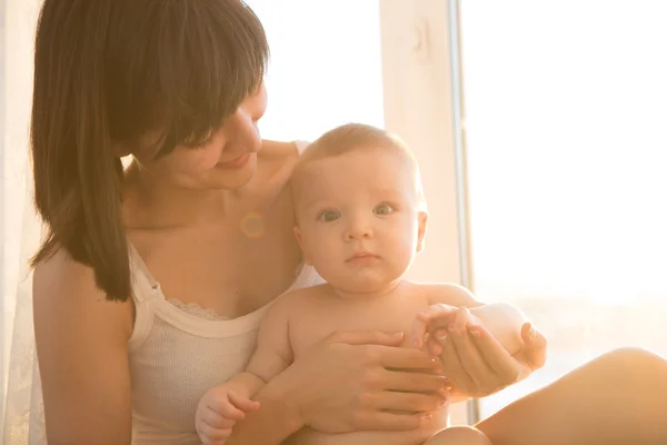 Mamma med bebis i rum hemma nära fönster — Stockfoto