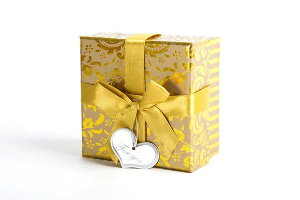 Arany ajándék doboz fehér háttér felett arany szalaggal. — Stock Fotó