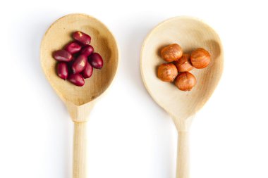 Fıstık ve fındık, tahta kaşık, üzerinde beyaz izole 