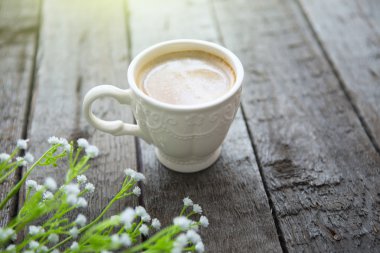 Masaya siyah kahve ve beyaz çiçek fincan
