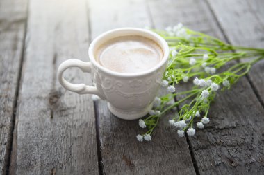 Masaya siyah kahve ve beyaz çiçek fincan