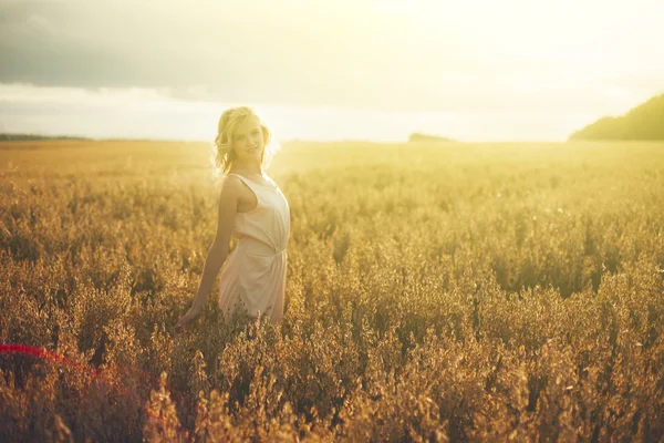 Schöne Frau zu Fuß auf Weizenfeld — Stockfoto