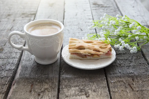 Jablečný koláč a kafe s květinami na stole — Stock fotografie