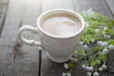 Masaya siyah kahve ve beyaz çiçek fincan