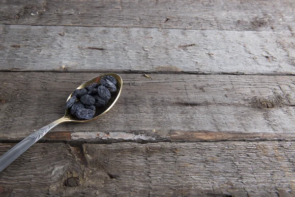 Raisins secs photo de dans cuillère en métal sur table marron — Photo