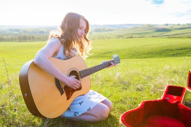 Güzel genç kız alanında gitar çalmak. 