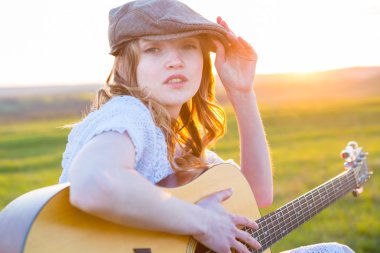 Parkta akustik gitar çalan kadın 