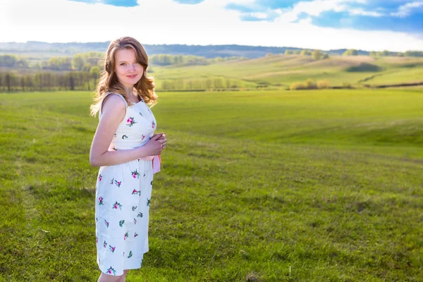 Dívka, venku užívat přírodu. Žena v bílých šatech na hřišti — Stock fotografie