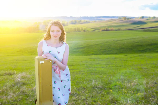 Žena v zeleném poli s akustická kytara — Stock fotografie