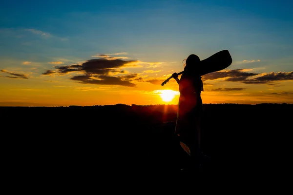 Silhouette Frau spielt Gitarre im Sonnenuntergang — Stockfoto