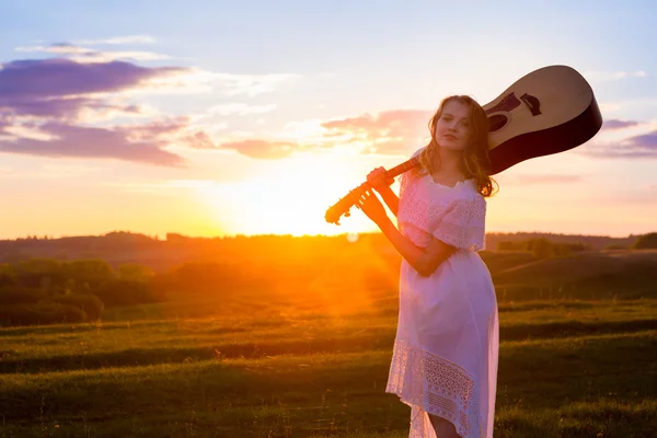 Porträt der schönen jungen Frau mit Gitarre im Feld — Stockfoto