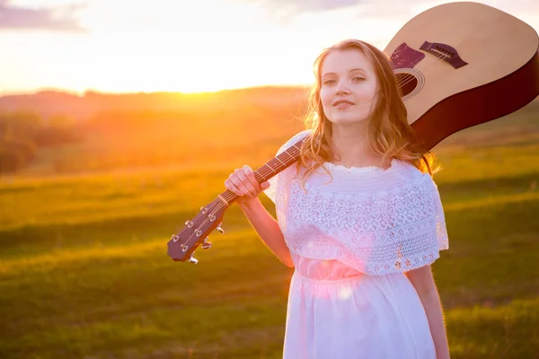 Portrait of the beautiful young woman  with guitar in field — Stock Photo, Image