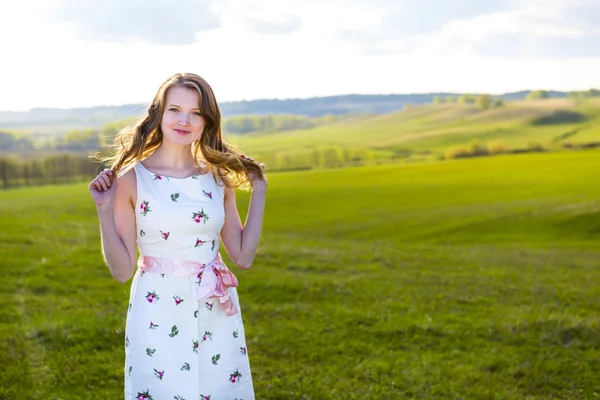 Meisje buitenshuis genieten van aard. Vrouw in witte jurk op veld — Stockfoto