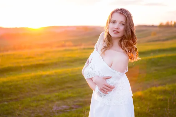 Bella donna sorridente in un campo al tramonto — Foto Stock