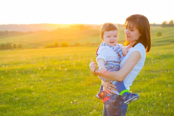 Madre e bel figlio a campo soleggiato con bagliore di sole . — Foto Stock