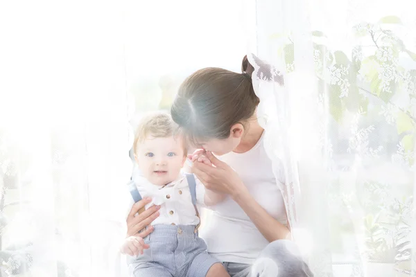 Keluarga bahagia yang ceria. Ibu dan bayi berciuman, tertawa dan memeluk — Stok Foto