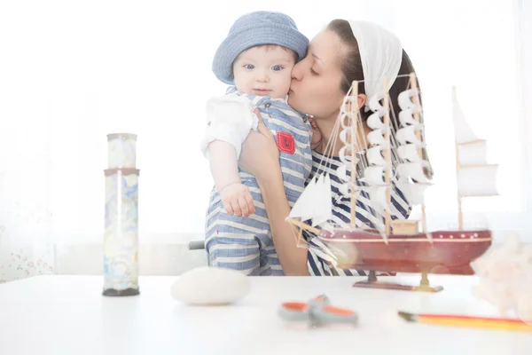 Travel concept. Happy sailor kid and mom playing indoors. — Stock Photo, Image