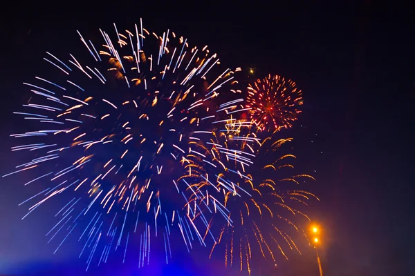 Fireworks in the evening sky with majestic clouds, long exposure — Stock Photo, Image