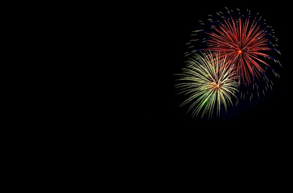 Fuochi d'artificio di festa colorati verdi e rossi su sfondo cielo nero . — Foto Stock