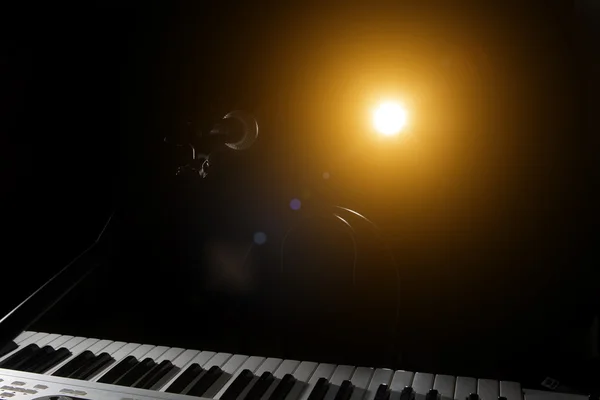 Micrófono y piano en fondo oscuro — Foto de Stock