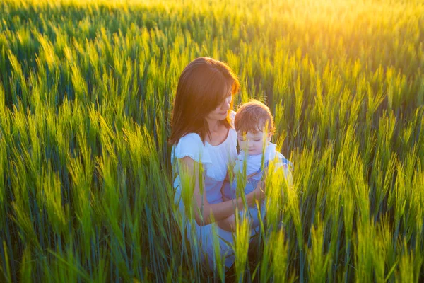 Beautiful woman with a baby in field — Stock Photo, Image
