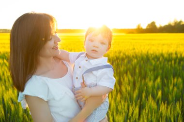 Güzel anne bebeğini alanındaki bir kucak vermek
