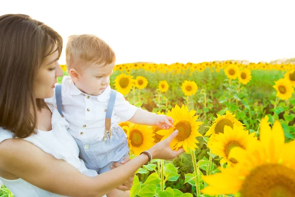 Happy family with sunflowers having fun outdoors in summer field — Stock Photo, Image