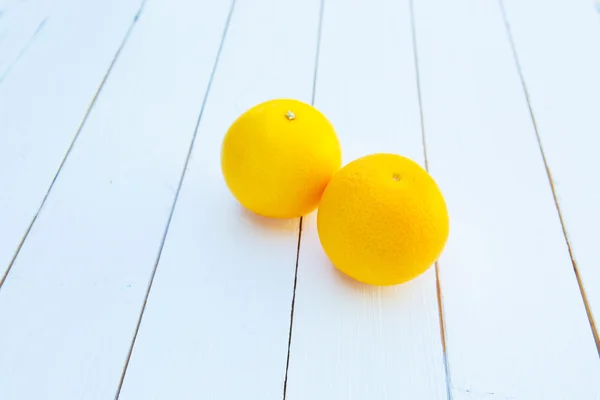Duas laranjas na mesa de madeira branca — Fotografia de Stock