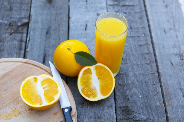 Zumo de naranja en vaso con cuchillo . —  Fotos de Stock