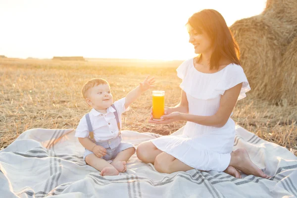 Liten söt baby med sin mor på picknick. — Stockfoto