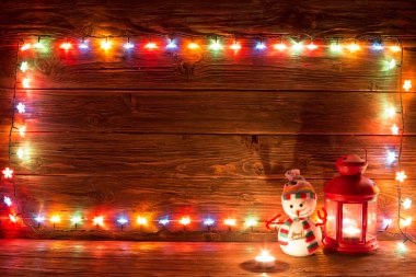 Noel ışıkları ve ahşap arka plan üzerinde vintage fener.