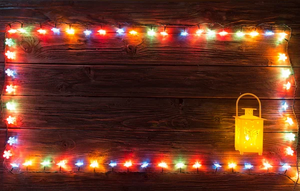 Weihnachtsgirlanden aus Lampen auf einem hölzernen Hintergrund. — Stockfoto