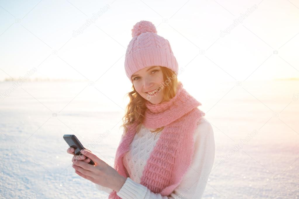The beautiful girl with a mobile phone in winter