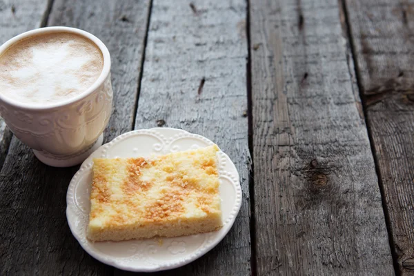 Cup of coffee with cake on dark table