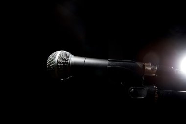 Koyu arka plan üzerinde siyah mikrofon.