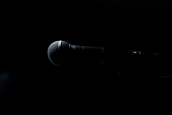 Micrófono negro sobre fondo oscuro . — Foto de Stock