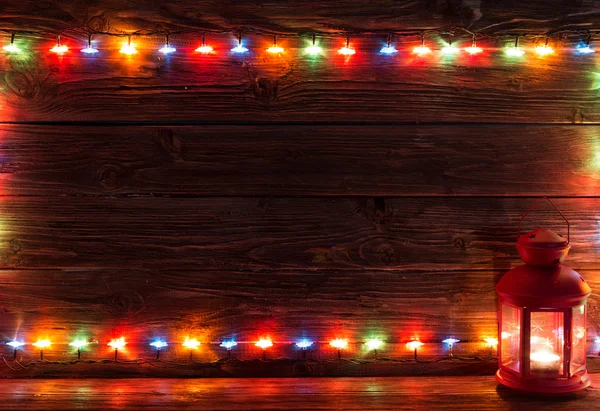 Luces de Navidad y linterna vintage sobre fondo de madera . — Foto de Stock