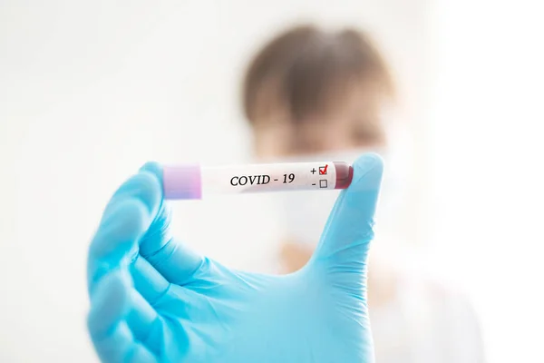 Жіноча медсестра тримає пробірку з аналізом крові з позитивним тестом COVID-19 — стокове фото