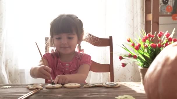 Little pretty girl painting halloween cookies — Stock Video