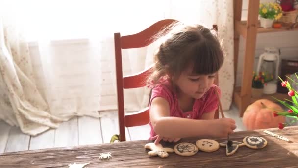 Cadılar Bayramı kurabiyeleri boyayan küçük güzel kız — Stok video