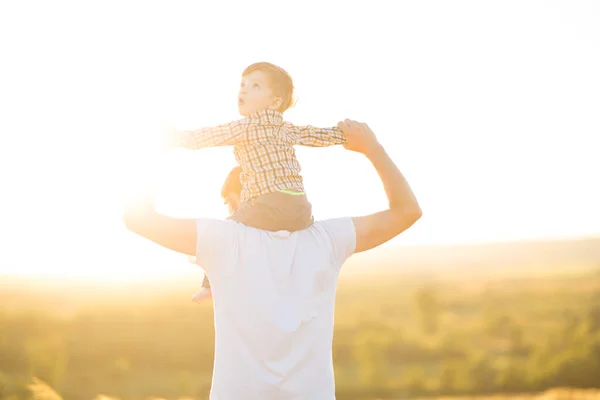 Sıcak ve güneşli bir günde parkta mutlu bir baba ve oğul. Aile ve aşk kavramı — Stok fotoğraf