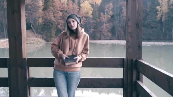 Das Mädchen ruht sich auf einer Wanderung aus. Lesen Sie ein Buch am Ufer eines Bergsees. Zeitlupenvideo — Stockvideo