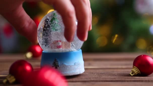 Christmas snow globe on background of christmas tree with christmas lights — Stock Video