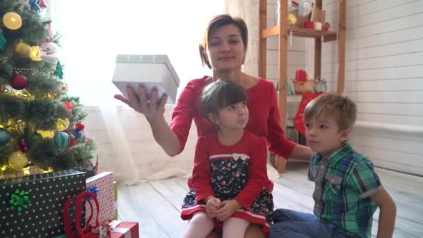 Feliz família e Feliz Natal. Mãe e seus filhos na manhã de Natal na árvore de xmas — Vídeo de Stock
