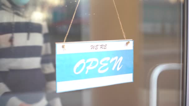 Gesloten voor zaken vanwege Covid. Kleine winkel zet gesloten bord op etalage — Stockvideo