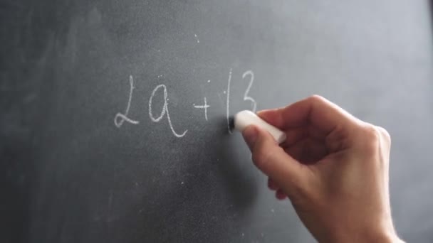 Womans hand with chalk writes a formula on a blackboard — Stock Video