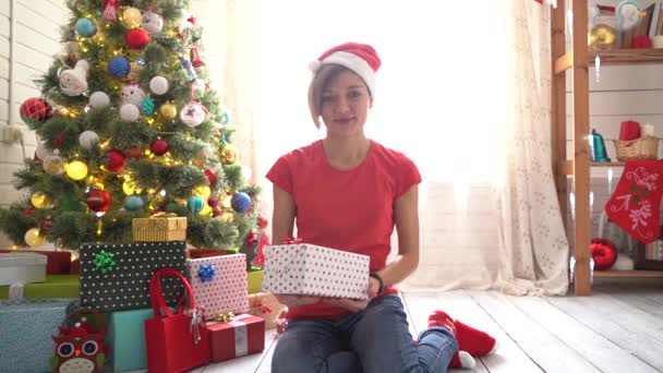 Uma mulher de chapéu de Pai Natal a dar um presente de Natal. Movimento lento — Vídeo de Stock